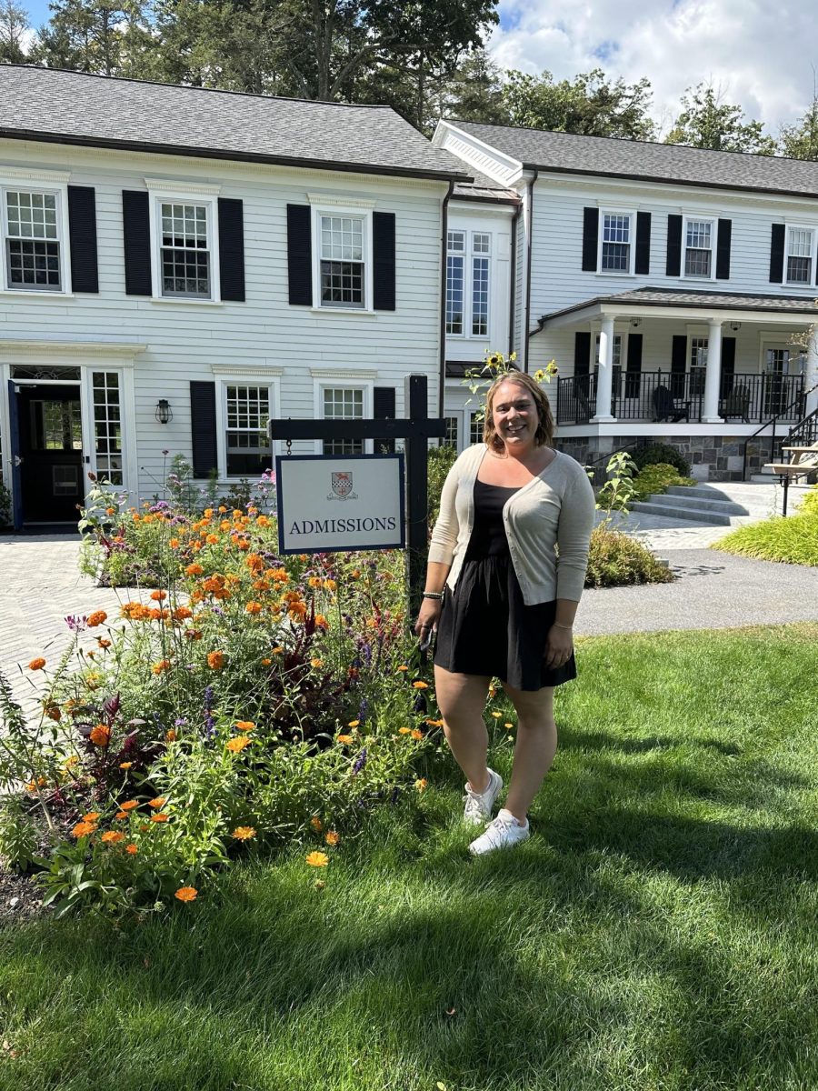 Ms. Quinones in front of the Admissions Building